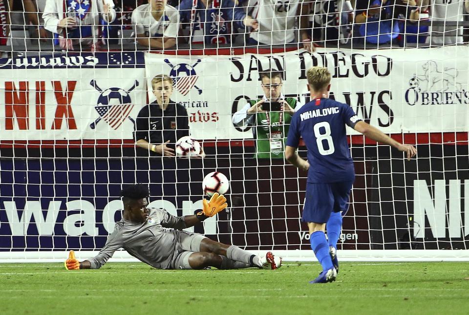 United States midfielder Djordje Mihailovic (8) scores a goal against Panama goalkeeper Eddie Roberts, left, during the first half of a men's international friendly soccer match Sunday, Jan. 27, 2019, in Phoenix. (AP Photo/Ross D. Franklin)