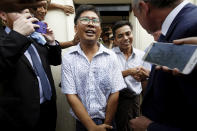 Reuters reporters Wa Lone, front center, and Kyaw Soe Oo, rear center, react as they are freed from Insein Prison in Yangon, Myanmar, Tuesday, May 7, 2019. Two Reuters journalists who were imprisoned for breaking Myanmar's Official Secrets Act over reporting on security forces' abuses of Rohingya Muslims were pardoned and released Tuesday, the prison chief and witnesses said. (Ann Wang/Pool Photo via AP)