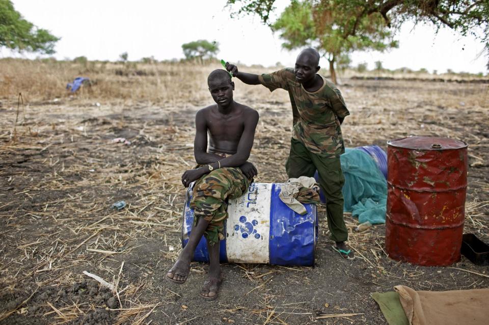 A Sudan People's Liberation Movement Army (SPLA) solider has his hair cut at a frontline position in Pana Kuach, Unity State, South Sudan on Friday, May 11, 2012. In late April, tensions between Sudan and South Sudan erupted into armed conflict along their poorly defined border. Thousands of SPLA forces have been deployed to Unity State where the two armies are at a tense stalemate around the state's expansive oil fields. Fighting between the armies lulled in early May after the U.N. Security Council ordered the countries to resume negotiations. South Sudan seceded from the Republic of Sudan in July 2011 following decades of civil war. (AP Photo/Pete Muller)