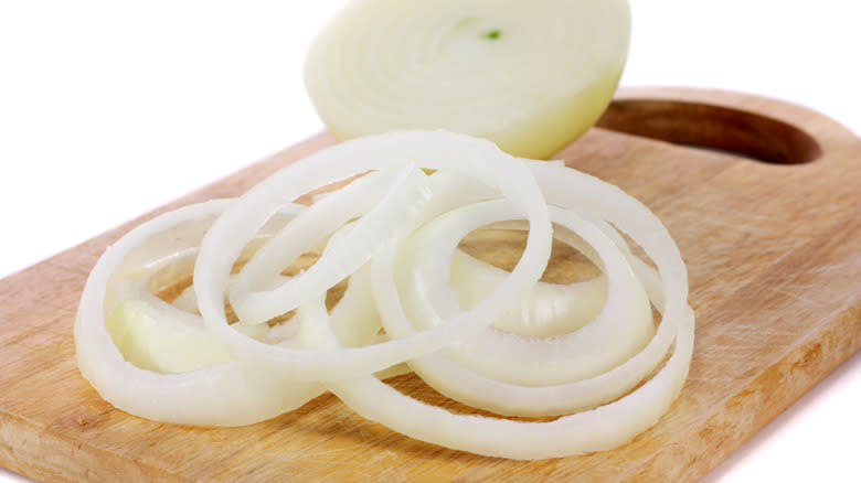 sliced onions on board