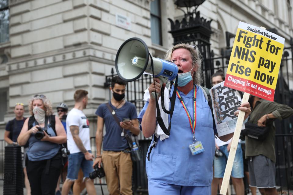 A NHS (National Health Service) worker protests outside Downing Street during a march through the streets of London on August 8, 2020, to demand a pay rise. (Photo by ISABEL INFANTES / AFP) (Photo by ISABEL INFANTES/AFP via Getty Images)