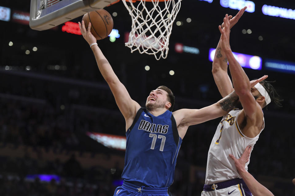 Dallas Mavericks guard Luka Doncic shoots a layup past Los Angeles Lakers center JaVale McGee during the second half of an NBA basketball game Sunday, Dec. 29, 2019, in Los Angeles. The Lakers won 108-95. (AP Photo/Michael Owen Baker)