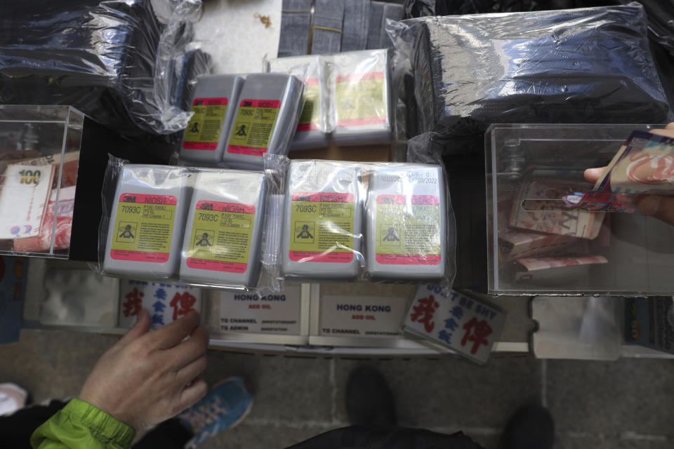 People donate money as they buy RFID-blocking sleeves for identity cards at a rally for students and elderly pro-democracy demonstrators in Hong Kong, Saturday, Nov. 30, 2019. Hundreds of Hong Kong pro-democracy activists rallied Friday outside the British Consulate, urging the city's former colonial ruler to emulate the U.S. and take concrete actions to support their cause, as police ended a blockade of a university campus after 12 days. (AP Photo/Ng Han Guan)