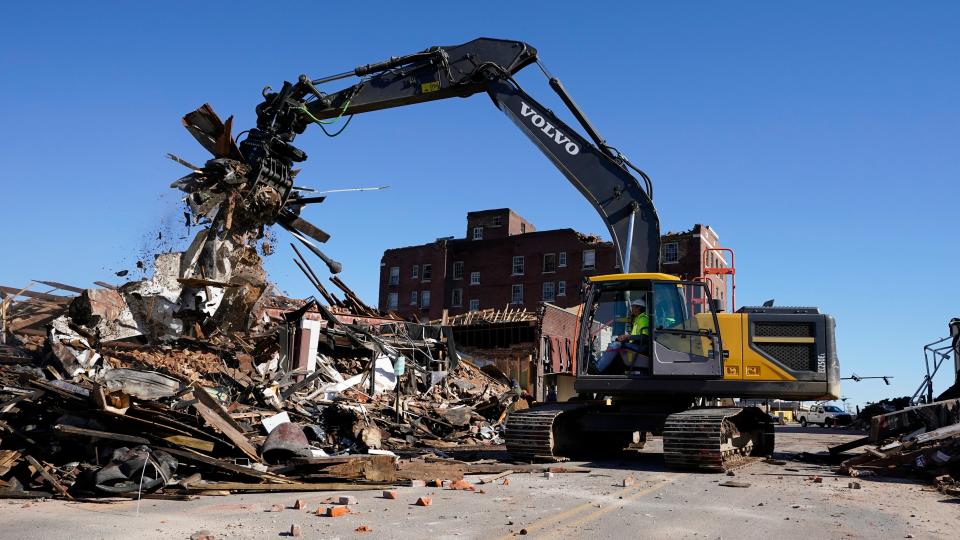 Workers remove debris from destroyed buildings Sunday, Dec. 12, 2021, in Mayfield, Ky. Tornadoes and severe weather caused catastrophic damage across several states Friday, killing multiple people overnight. (AP Photo/Mark Humphrey)