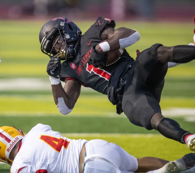 San Clemente, CA - April 16: San Clemente running back James Bohls leaps over a tackling Mission Viejo linebacker Brenndan Warady in the second quarter at San Clemente High School on Friday, April 16, 2021 in San Clemente, CA. (Allen J. Schaben / Los Angeles Times)