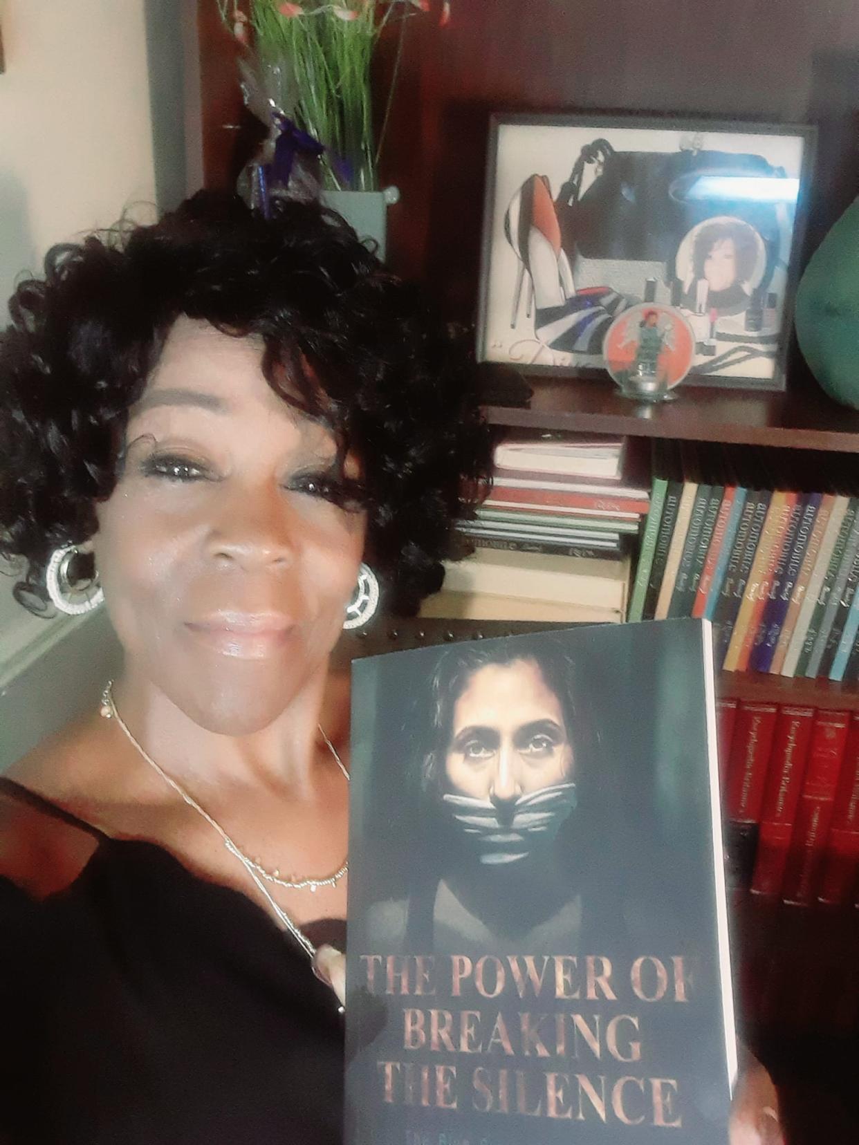 Battle Creek author Doris Taylor poses with her new book, "The Power Of Breaking The Silence: The Blue Print of a Survivor." Taylor collaborated with six other domestic violence survivors on the project.
