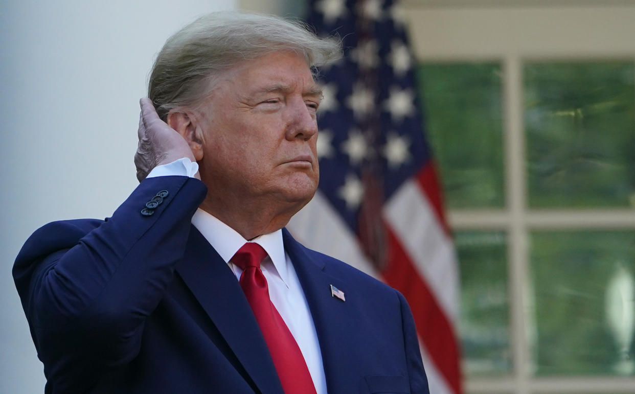 US President Donald Trump pats down his hair as he speaks during the Coronavirus Task Force  daily briefing on COVID-19 in the Rose Garden of the White House in Washington, DC on March 30, 2020. (Photo by MANDEL NGAN / AFP) (Photo by MANDEL NGAN/AFP via Getty Images)