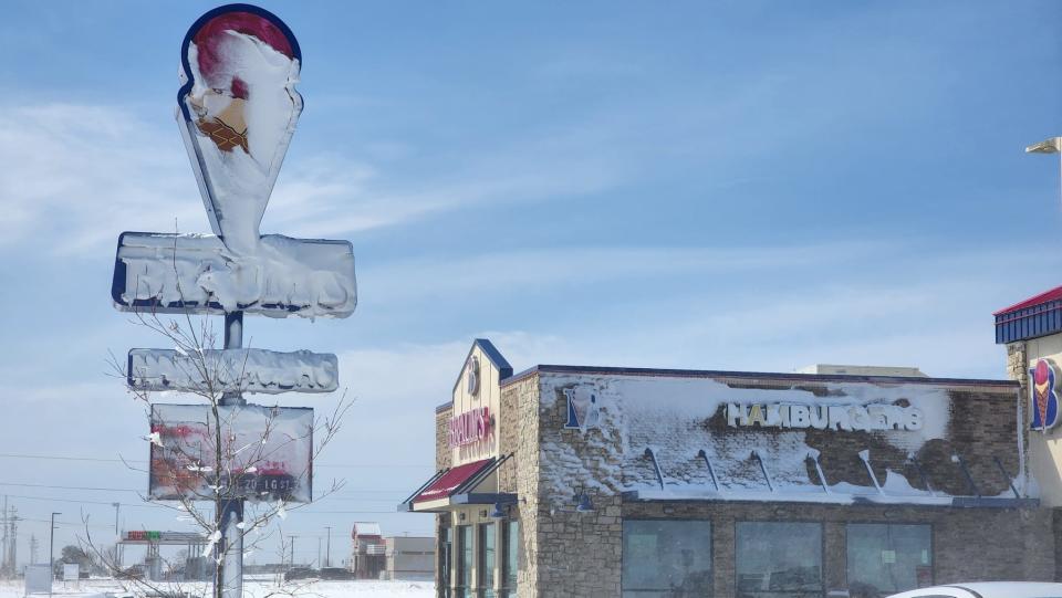 A Braums sign is nearly completely covered by snow after a mix of strong winds and snowfall overnight earlier this year, as seen in this file photo. An arctic front is going to bring extreme cold temperatures and wind chills to the area this weekend.