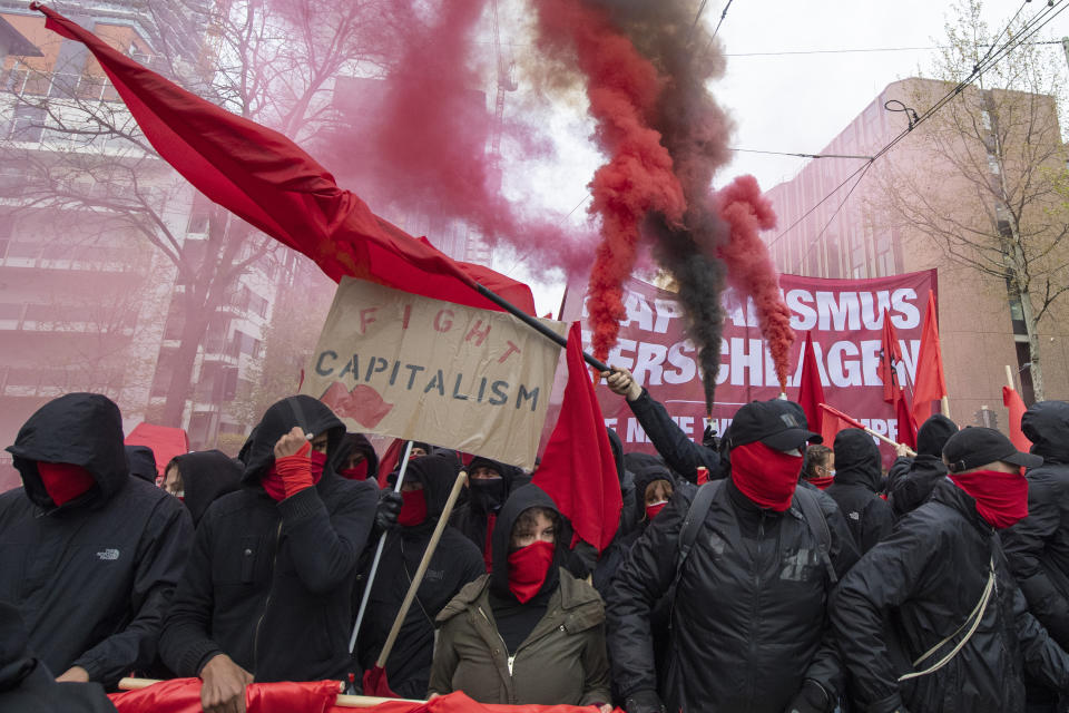 Hooded participants of the "Revolutionary May Day Demonstration" march in streets in Frankfurt Saturday, May 1, 2021. (Boris Roessler/dpa via AP)