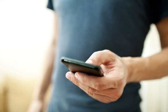 Close up on a man's hand holding a smartphone.