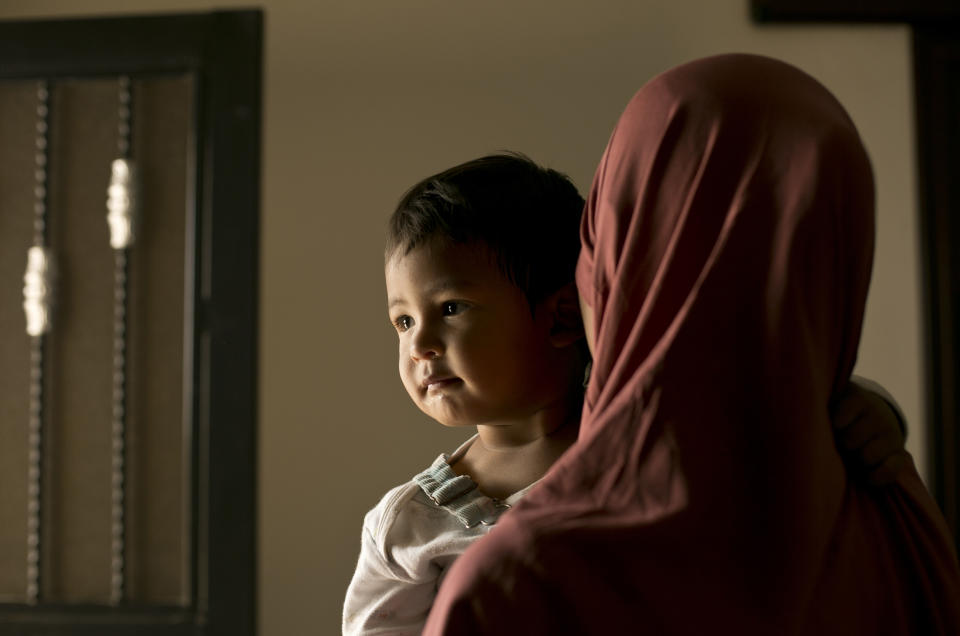 In this March 26, 2019, photo, Aliya, a 24 year-old Indonesian national, poses for a portrait with her son, Yahya, at Camp Roj in north Syria. Aliya said that back home she grew up in a conservative Muslim family but was not herself practicing. Then her boyfriend broke up with her and, brokenhearted, she threw herself into religion. To “make up for” her past, she said she went far to a hard-line direction, watching videos of IS sermons. “I believed they were the real Islamic state,” she said. (AP Photo/Maya Alleruzzo)