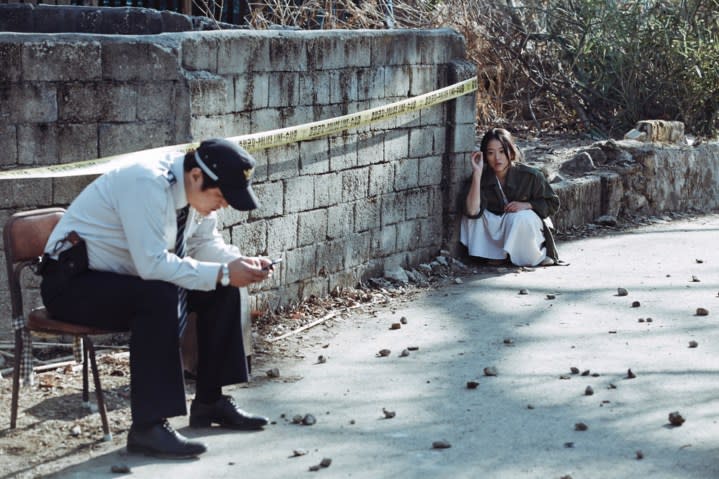 A man and woman sitting outdoors in The Wailing.