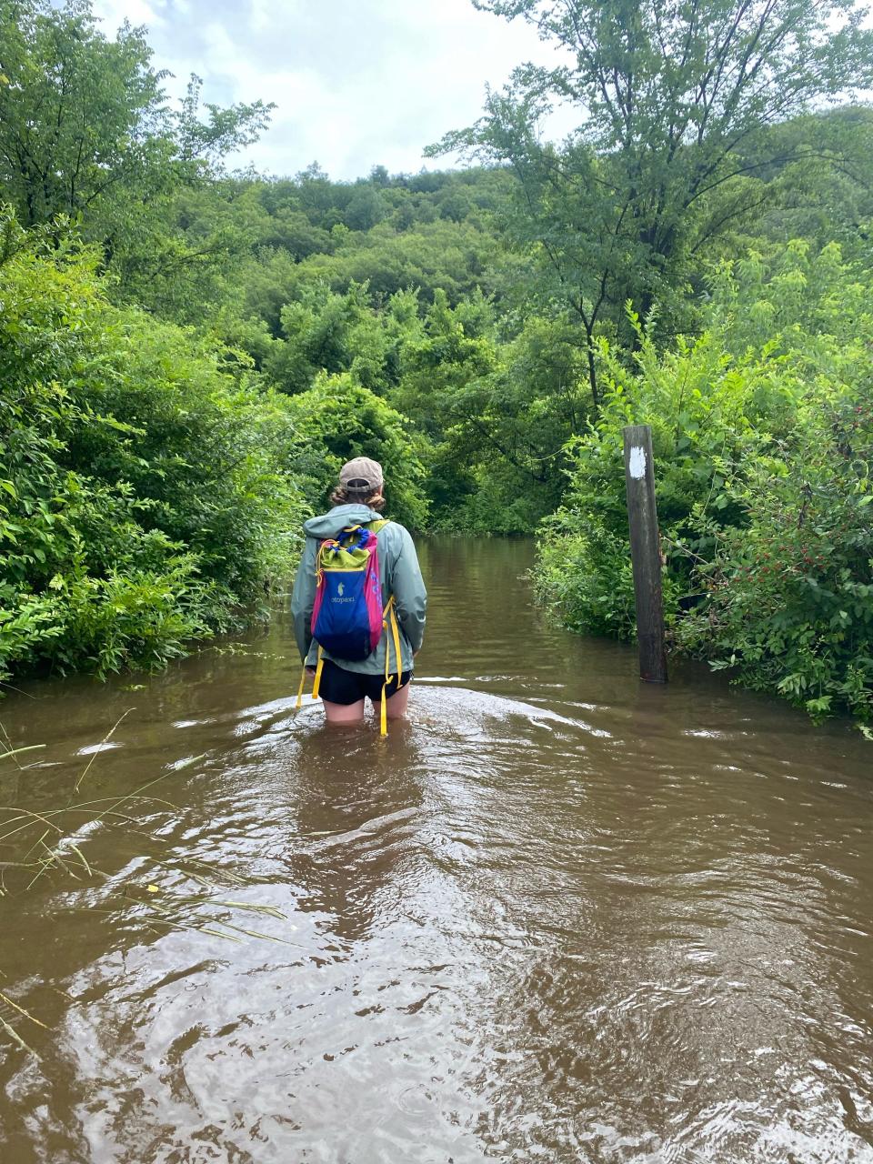 Alexis Holzmann wades through murky water near the Housatonic River in Connecticut as parts of the Appalachian Trail she is hiking were flooded after the storms July 9-10.