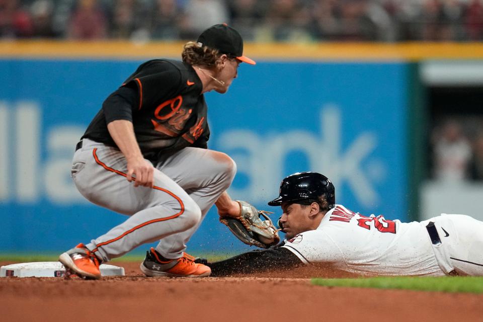 Cleveland Guardians' Josh Naylor, right, advances to second base under the tag of Baltimore Orioles third baseman Gunnar Henderson, left, on a wild pitch during the seventh inning of a baseball game Friday, Sept. 22, 2023, in Cleveland. (AP Photo/Sue Ogrocki)