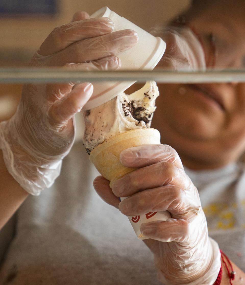 Emilia Gonzales takes ice cream from a cup and puts into a cone for a customer on Friday, September 3, 2021, at Delicias Monarca on Franklin Road in Indianapolis. 