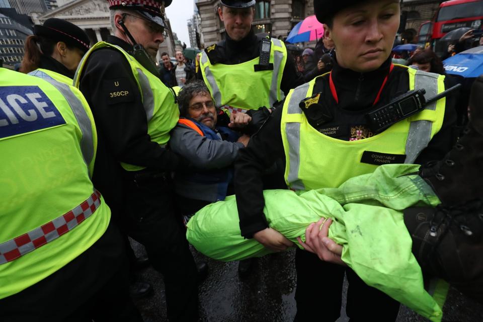 A protester is carried away by police as others block the road in front of the Bank of England. (PA)