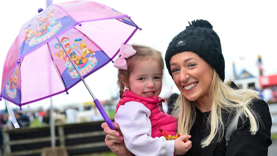 A woman and child holding an umbrella