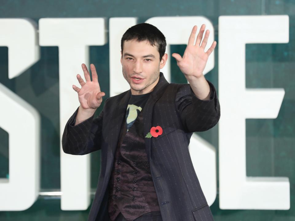 Ezra Miller waving their hands.