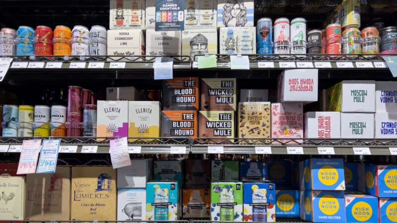 A grocery aisle with various boxes of canned cocktails