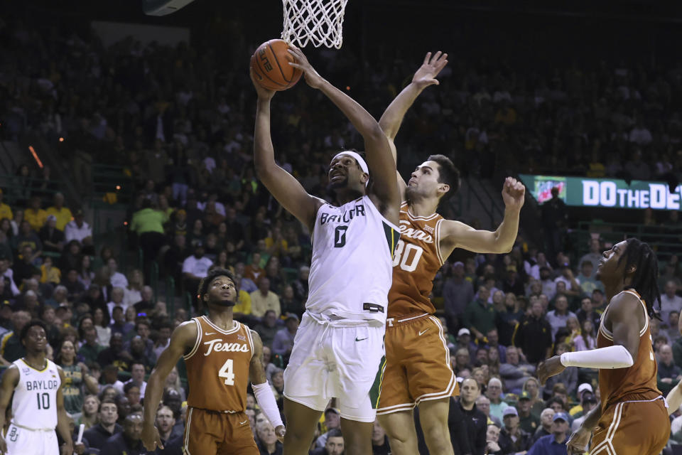 Baylor forward Flo Thamba (0) is fouled by Texas forward Brock Cunningham (30) as he attempts to score during the second half of an NCAA college basketball game Saturday, Feb. 25, 2023, in Waco, Texas. (AP Photo/Jerry Larson)
