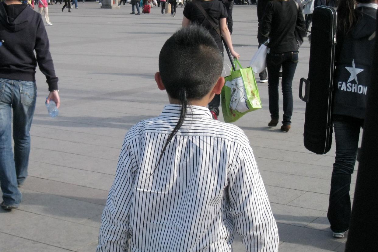 Back of a young boy's head with a rat tail haircut