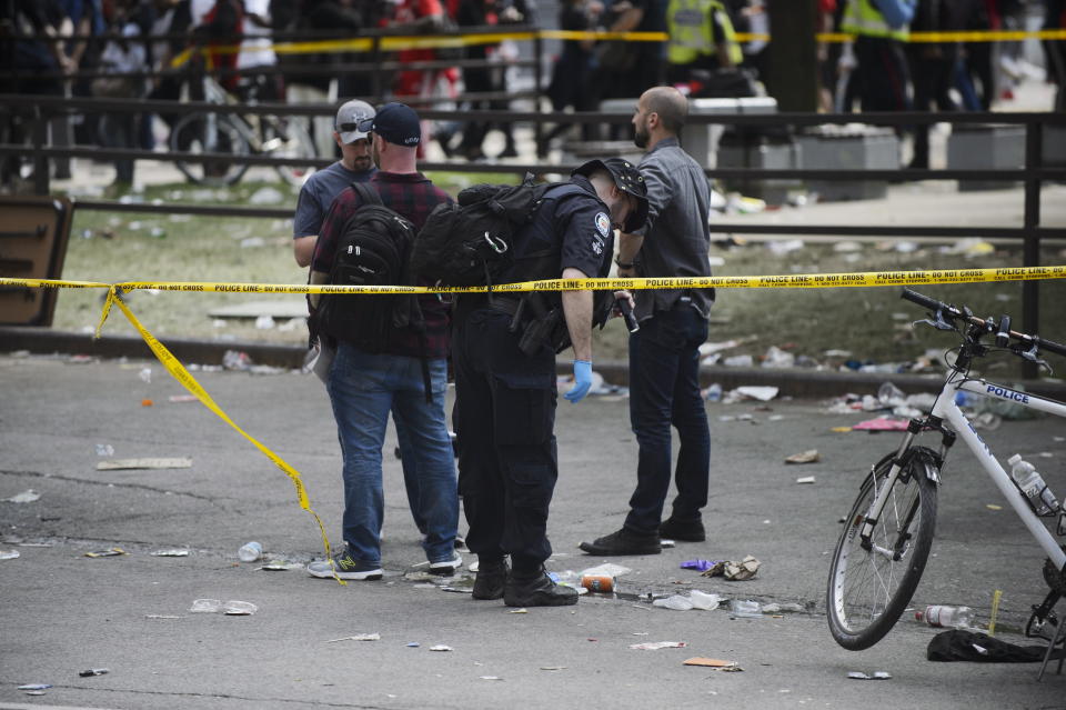 Toronto Police search for evidence after shots were fired during the Toronto Raptors NBA basketball championship parade in Toronto, Monday, June 17, 2019. (Andrew Lahodynskyj/The Canadian Press via AP)