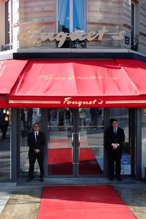 Employees guard the entrance of the Fouquet's restaurant on the eve of its reopening on the Champs Elysees, almost 4 months after it was ranksacked by a "yellow vests" protest in Paris