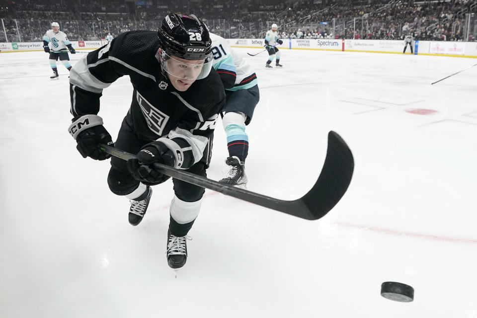 Los Angeles Kings center Jaret Anderson-Dolan, left, chases the puck while under pressure from Seattle Kraken right wing Daniel Sprong during the third period of an NHL hockey game Tuesday, Nov. 29, 2022, in Los Angeles. (AP Photo/Mark J. Terrill)