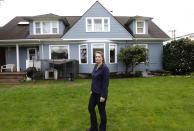 Erica Hollen stands in the yard of her home in Hoquiam, Wash. on Monday, March 18, 2014. Hollen is worried that possible food insurance rate increases would be unaffordable or prevent her and her husband from eventually selling their home. (AP Photo/Ted S. Warren)