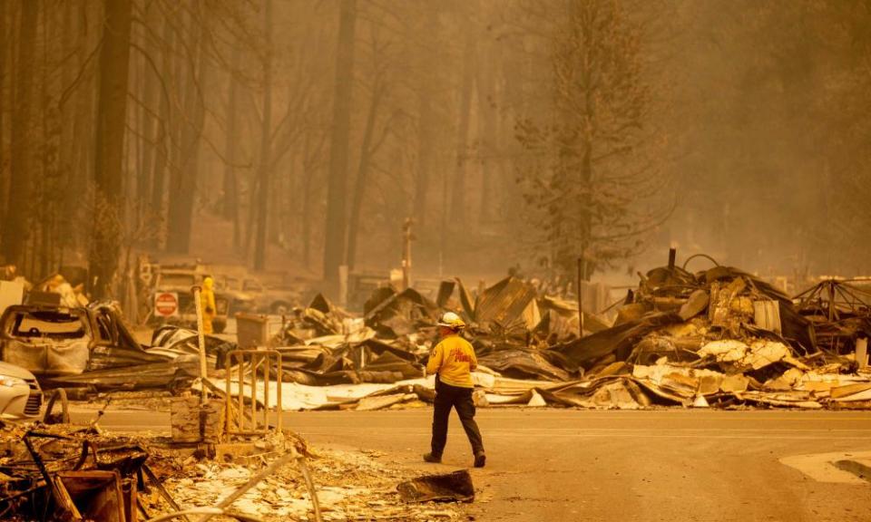 firefighter looking at burned ruins of town