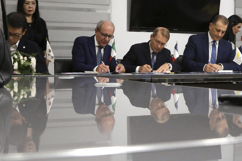 Cyprus' Energy Minister Georgios Lakkotrypis, right, General Manager of Total in Cyprus Yves Grosjean, second right, Manager director of ENI Cyprus Allesandro Barberis, second left, and Director of Kongas Cyprus Insu Woo sign a deal at the Energy ministry in Nicosia, Cyprus, Wednesday, Sept. 18, 2019. Cyprus' energy minister says a consortium made up of energy companies Total of France and Eni of Italy has been granted a license to explore for natural gas deposits in another area off Cyprus' southern coast. (AP Photo/Petros Karadjias)