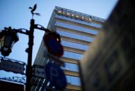 The signage of Ginza Six, a luxury shopping complex, is seen through street signs, in Tokyo