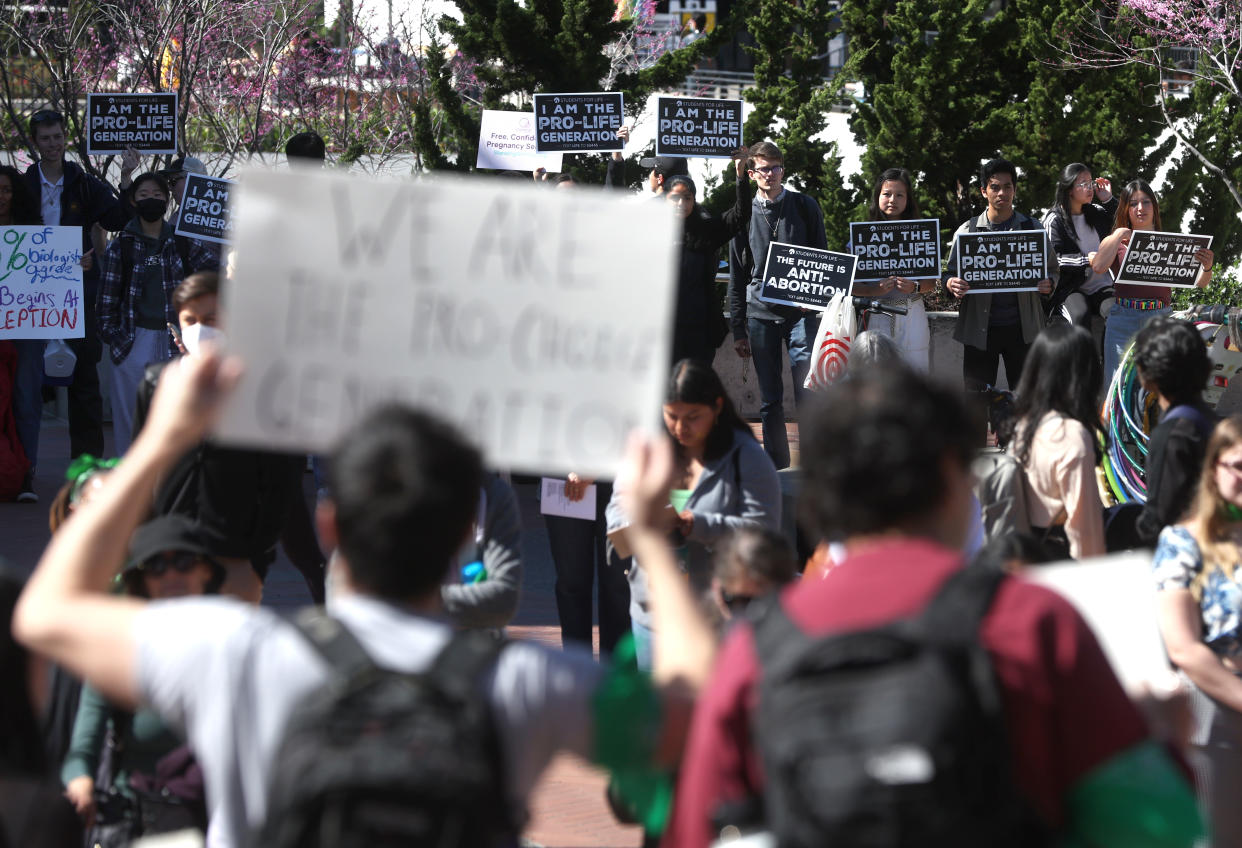 Anti-abortion demonstrators hold signs as they stage a counterprotest on the steps of Sproul Hall on the UC Berkeley campus. 