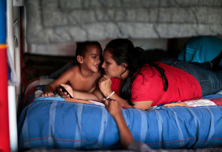 FILE PHOTO: Honduran citizen Brenda Maribel Perdomo listens to her son Jefferson at the Todo por ellos (All for them) immigrant shelter in Tapachula, Chiapas, in southern Mexico, June 26, 2014. During the eight months ending June 15, some 52,000 children were detained at the U.S. border with Mexico, most of them from Central America. Driven largely by poverty and gang violence at home, the wave has swelled again in the last few months, although with a new dynamic as more children make the trek, many traveling without parents or relatives to care for them. Picture taken June 26, 2014. REUTERS/Jorge Dan Lopez/File Photo