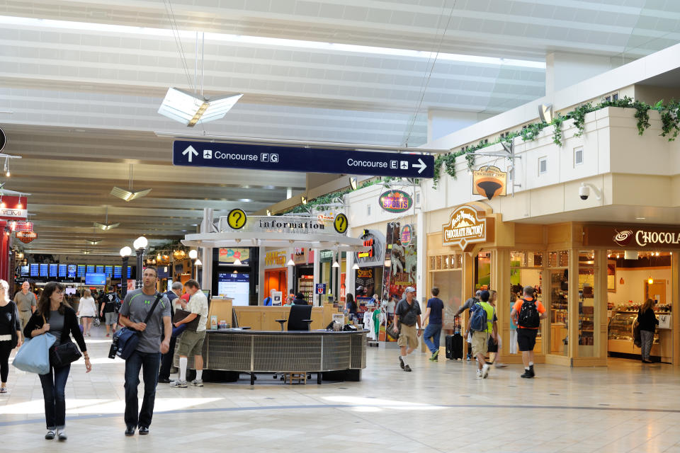 Passengers walking or shopping in stores at Minneapolis - Saint Paul International Airport. (Photo: Getty)