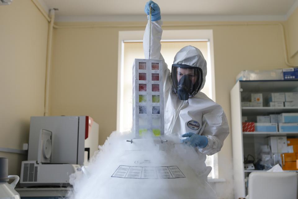 In this handout photo taken on Thursday, Aug. 6, 2020, and provided by Russian Direct Investment Fund, an employee works with a coronavirus vaccine at the Nikolai Gamaleya National Center of Epidemiology and Microbiology in Moscow, Russia. Russia on Tuesday, Aug. 11 became the first country to approve a coronavirus vaccine for use in tens of thousands of its citizens despite international skepticism about injections that have not completed clinical trials and were studied in only dozens of people for less than two months. (Alexander Zemlianichenko Jr/ Russian Direct Investment Fund via AP)