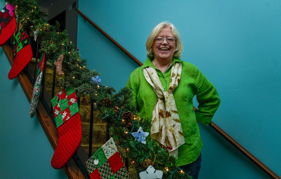 Diane Evans poses inside her Oak Creek home on Nov. 16. She made all the stockings by hand.