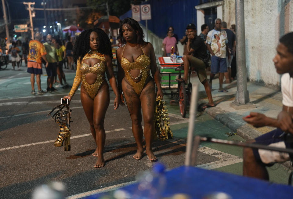 Bailarinas de la escuela de samba Paraiso do Tuiuti llevan sus tacones en la mano a un ensayo antes de las fiestas de Carnaval en Río de Janeiro, Brasil, el lunes 15 de enero de 2024. (AP Foto/Silvia Izquierdo)