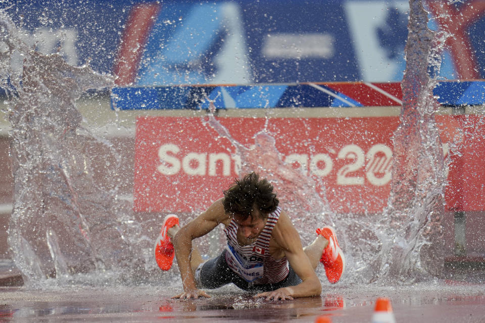 El canadiense Jean-Simon Desgagnes cae a la ría durante la final del steeplechase en los Juegos Panamericanos de Santiago, el 4 de noviembre de 2023 (AP Foto/Fernando Vergara).