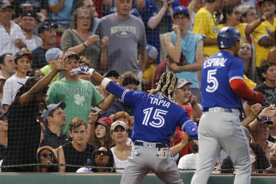 Toronto Blue Jays' Raimel Tapia (15) interacts with a fan after hitting an inside-the-park grand slam against the Boston Red Sox during the third inning of a baseball game Friday, July 22, 2022, in Boston. (AP Photo/Michael Dwyer)