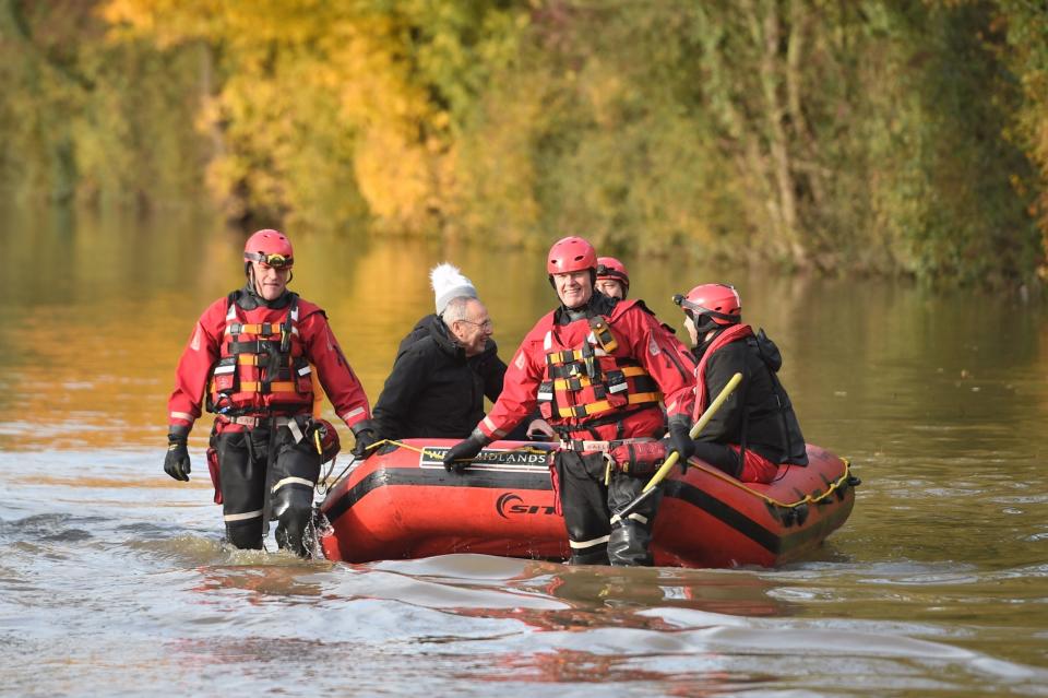 Members of West Midlands Fire Service help to rescue residents from floodwater near Fishlake (PA)