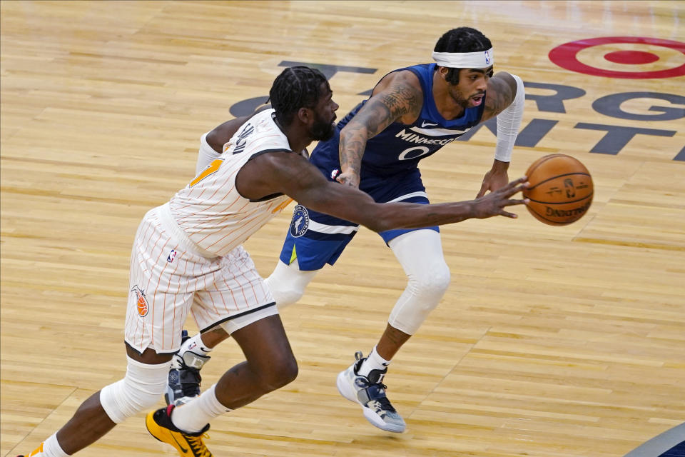 Orlando Magic's James Ennis III, left, drives as Minnesota Timberwolves' D'Angelo Russell defends during the first half of an NBA basketball game Wednesday, Jan. 20, 2021, in Minneapolis. (AP Photo/Jim Mone)