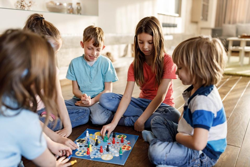 group of children sitting on floor playing board game