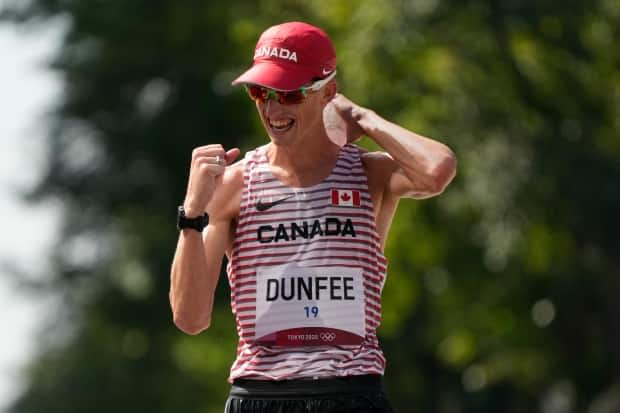 Canadian Evan Dunfee celebrates after crossing the finish line to win bronze in the men's 50-kilometre race walk at Tokyo 2020 on Thursday. (Shuji Kajiyama/The Associated Press - image credit)