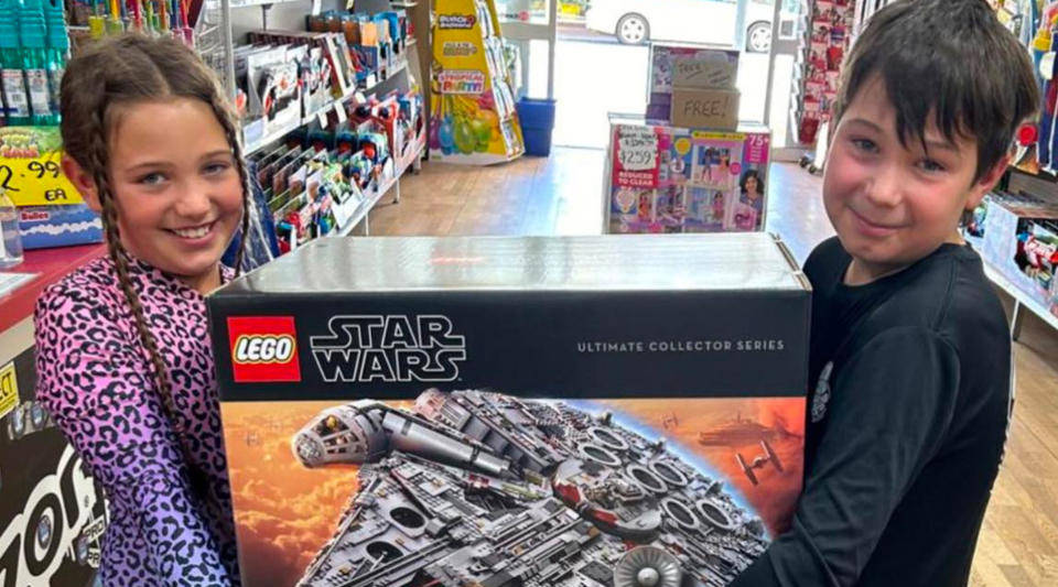 Two smiling siblings holding a lego set in a WA toy store.