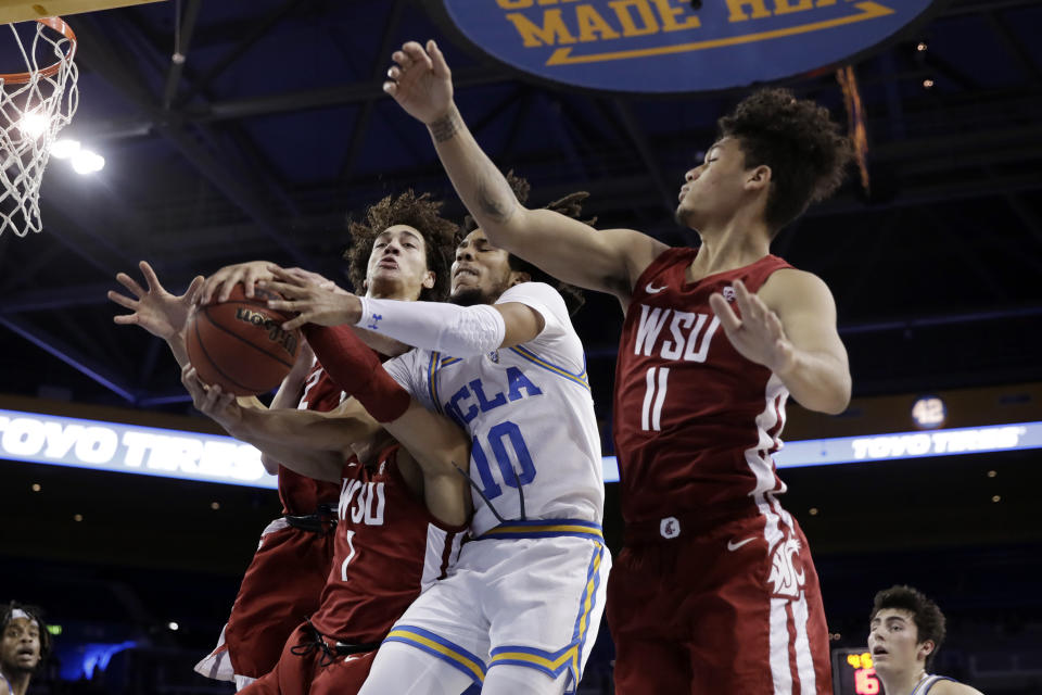 UCLA guard Tyger Campbell (10) vies for a rebound against Washington State guard Jervae Robinson (1) and forward DJ Rodman (11) during the first half of an NCAA college basketball game Thursday, Feb. 13, 2020, in Los Angeles. (AP Photo/Marcio Jose Sanchez)