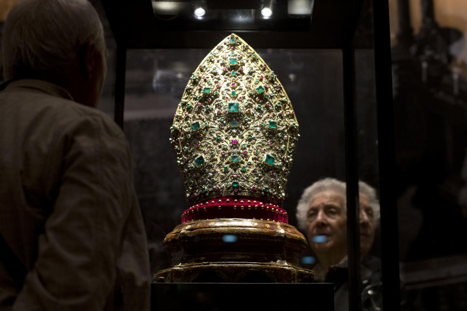 A visitor looks at a Mitre created in 1713, part of the exhibition "Naples' Treasure. Masterpieces from the Museum of Saint Januarius", on display at the Fondazione Roma Museum, in Rome's Palazzo Sciarra, Wednesday, Oct. 30, 2013. The two most valuable pieces exhibited are the Mitre and a necklace, begun in 1679 by goldsmith Michele Dato. (AP Photo/Andrew Medichini)