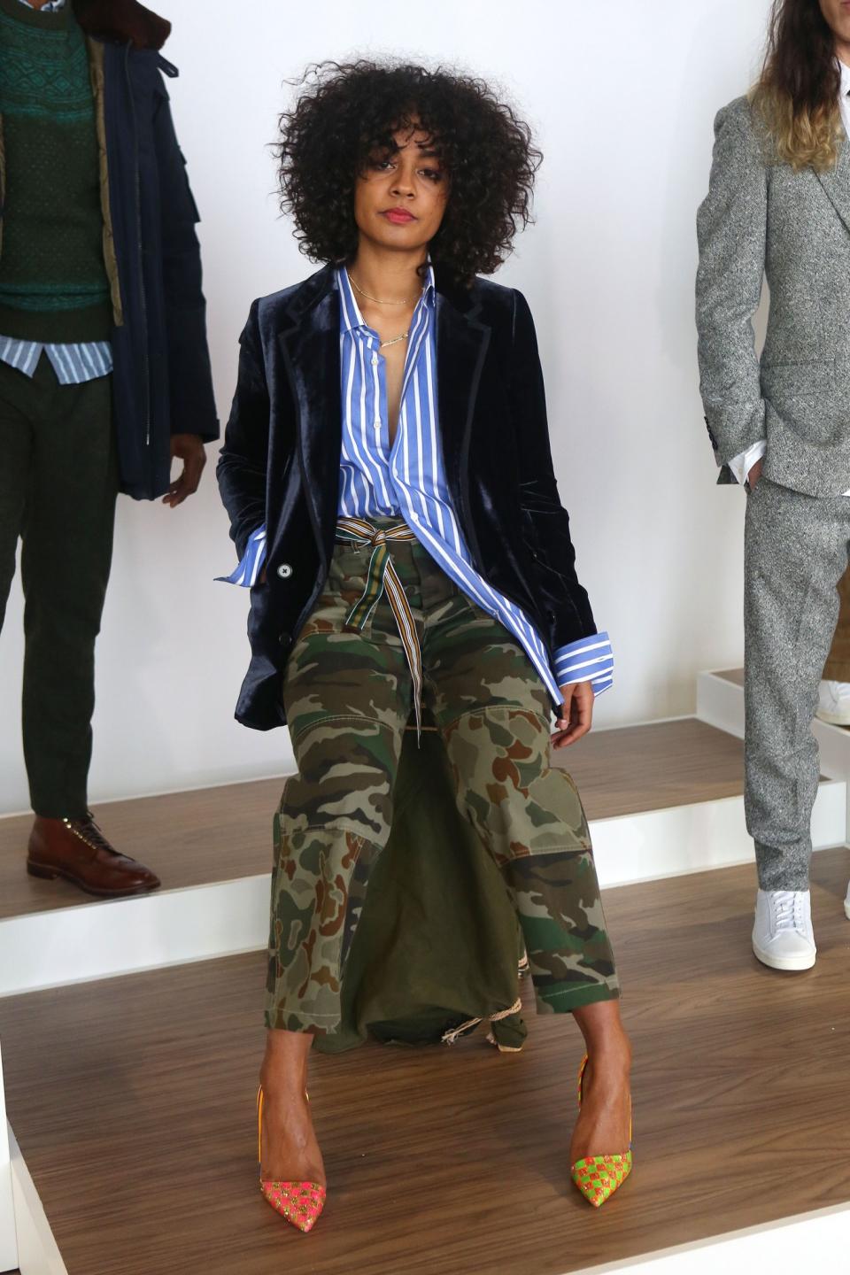 Artistic and edgy, this model shows a laid-back persona wearing camo pants and loose-fitted striped shirt and navy blazer.