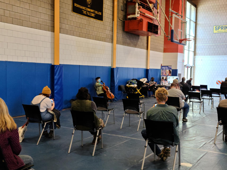 This photo provided by Berkshire Community College shows cellist Yo-Yo Ma performing at Berkshire Community College’s second dose Pfizer vaccination clinic in the Paterson Field House on Saturday, March 13, 2021 in Pittsfield, Mass. Newly vaccinated Massachusetts residents were treated to a mini concert when the famed cellist brought out his instrument after getting his second shot. (Jonah Sykes/Berkshire Community College via AP)