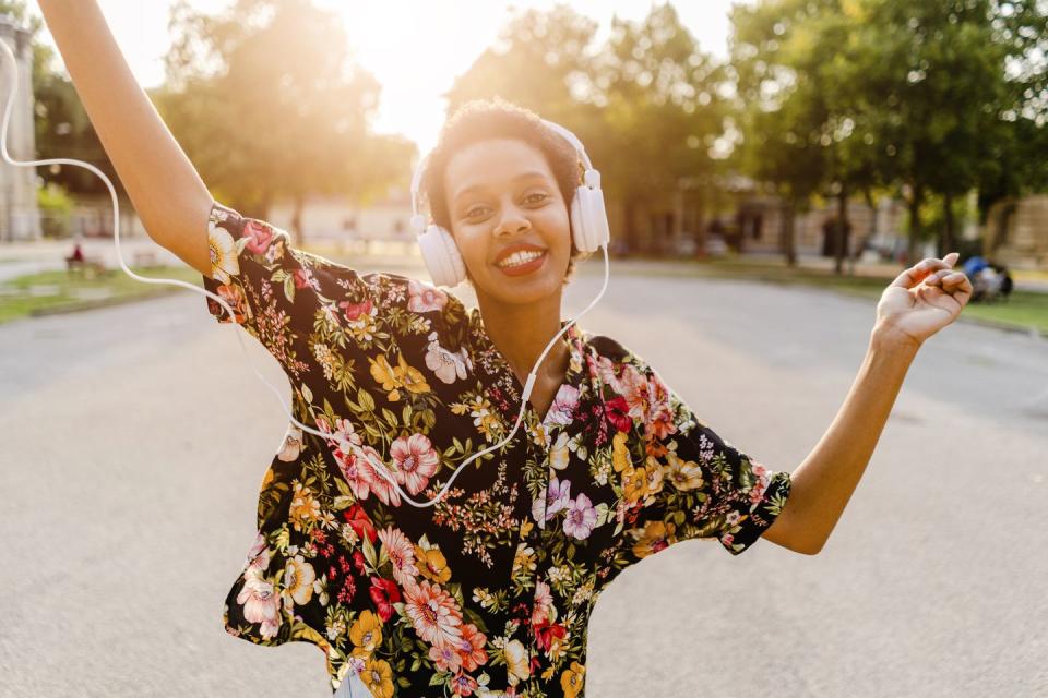 summer activities young woman wearing headphones and dancing